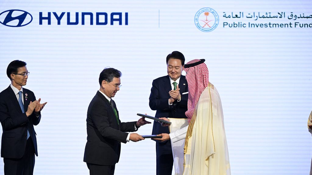 South Korean President, Yoon Suk Yeol, claps as Hyundai Motor President, Chang Jae-hoon, exchanges agreements on joint investment in auto production with a deputy governor of Saudi Arabia's Public Investment Fund (PIF), Yazeed Alhumied.